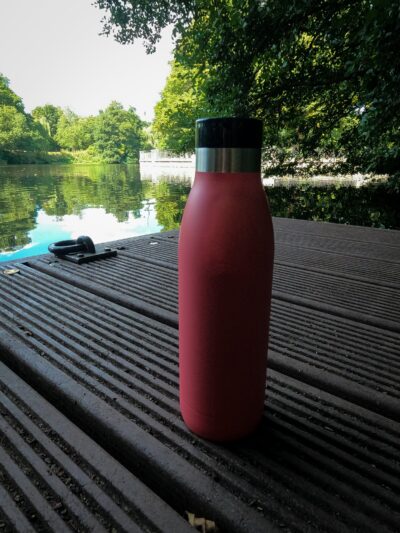 Eine rote Emsa N31104 Bludrop Color Thermosflasche auf einem Steg