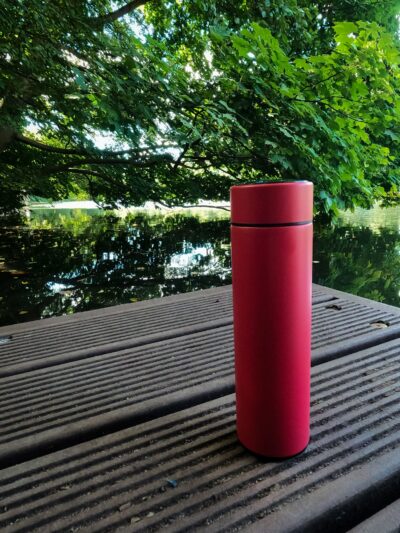 Eine rote Flintronic Thermosflasche auf einem Steg