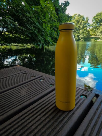 Eine gelbe LARS NYSØM Thermosflasche auf einem Steg