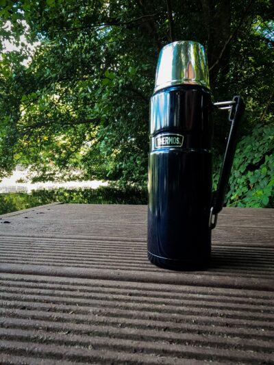 Eine dunkelblaue Thermos 183267 Stainless King Thermosflasche auf einem Steg
