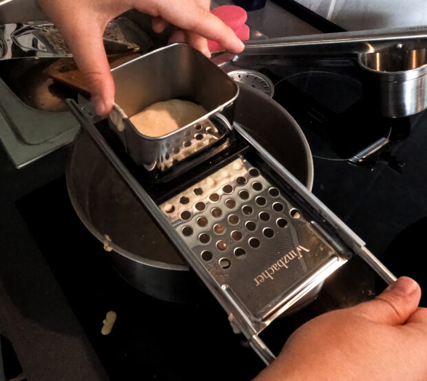 Teig wird durch den Winzbacher® Edelstahl Spätzlehobel in den Topf gelassen